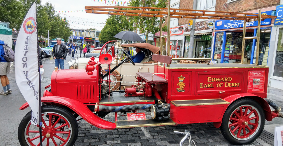 A red vintage car named Edward Earl of Derby at West End Carnival